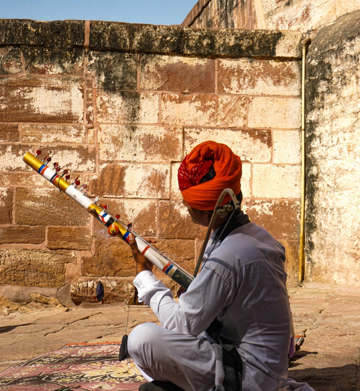 An artist playing a traditional instrument outdoors